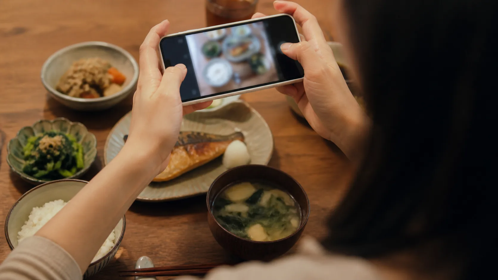 食事の写真をスマホで撮って、報告しているところ