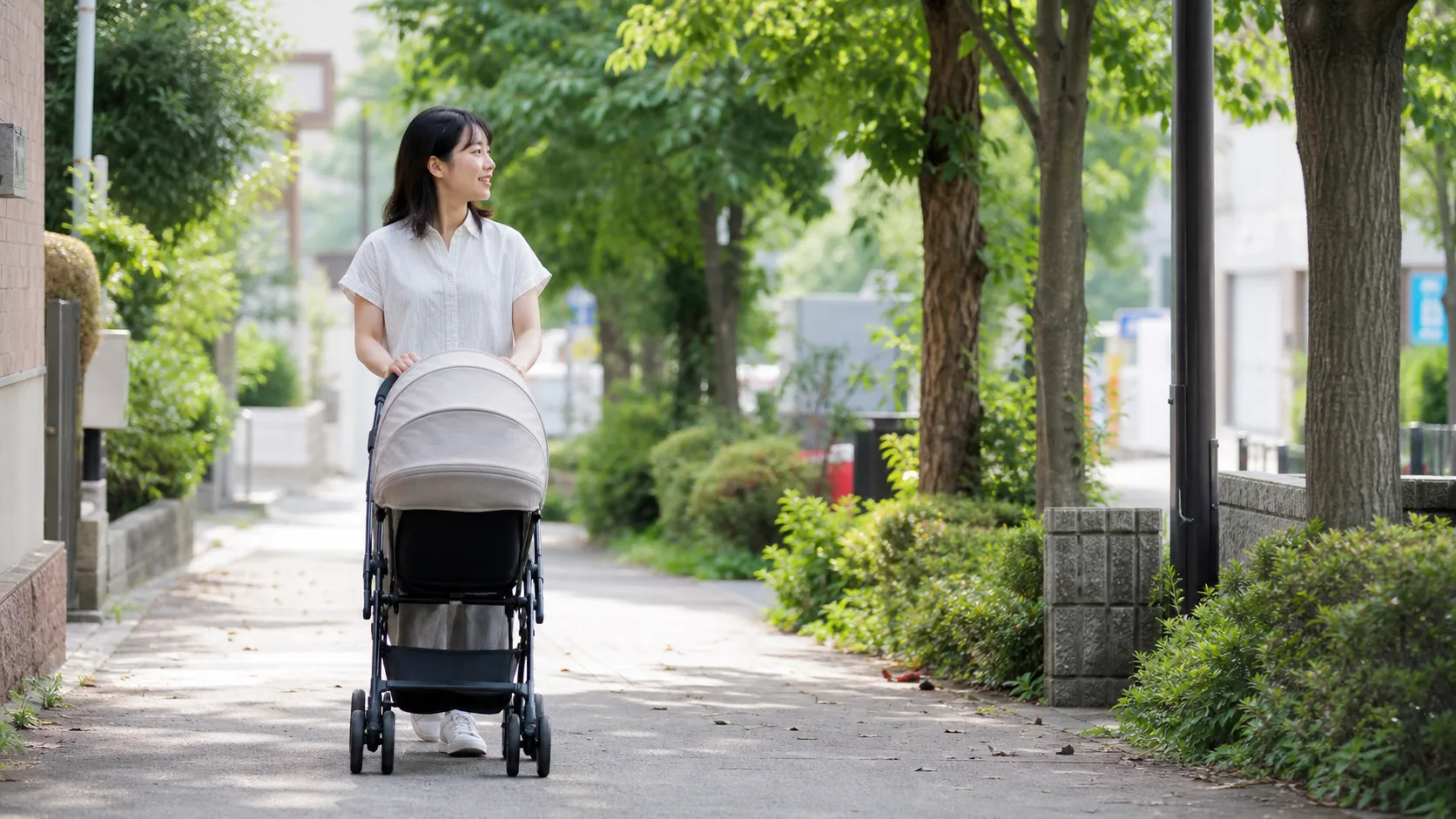 昼下がりに、ベビーカーを押して明るい道を歩いているところ
